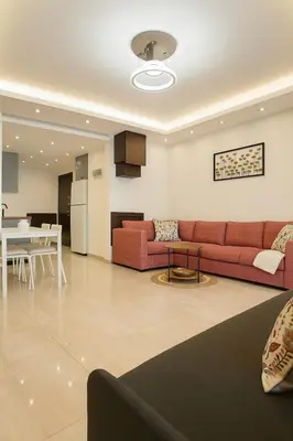 a living room with a red couch and a table at Elite Apartment Compound 1 in Amman
