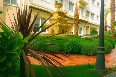 a house with a palm plant next to a street light at Elite Apartment Compound 1 in Amman
