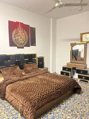 a bedroom with a large bed and a mirror at دار الخير للشقق المفروشة in Al Mafraq