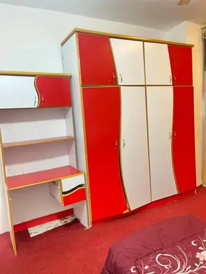 a room with red and white shelves and a bed at دار الخير للشقق المفروشة in Al Mafraq