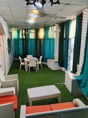a room with a table and chairs and blue curtains at دار الخير للشقق المفروشة in Al Mafraq