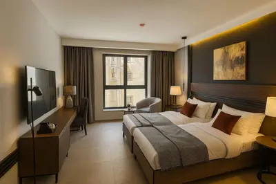 a hotel room with a large bed and a window at Crystal Collection Hotel in Amman