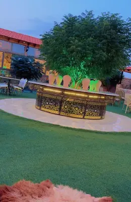 a group of chairs and a table with a tree at The modern village in ‘Ayn Amūn