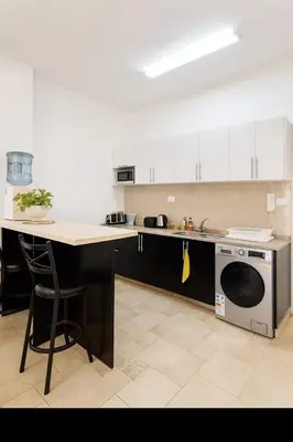 a kitchen with a counter and a sink and a dishwasher at Rainbow Street Studio Cozy Central in Amman