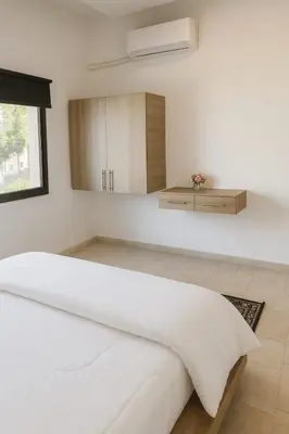 a bedroom with a white bed and a mirror at Rainbow Street Studio Cozy Central in Amman