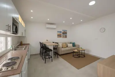 a kitchen and living room with a couch and a table at Rainbow Street Studio Cozy Central in Amman