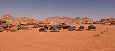 a group of tents in the desert with mountains at Bedouin Horizons in Wadi Rum