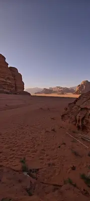 an empty desert with rocks in the background at Bedouin Horizons in Wadi Rum