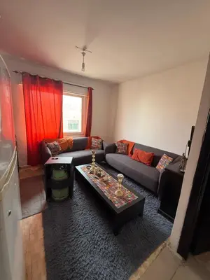 a living room with a couch and a table at Al Jubaiha cozy studio 2 in Amman