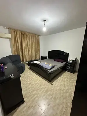 a living room with a bed and a couch at Al Jubaiha cozy studio 2 in Amman