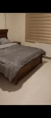 a bed with a wooden frame in a bedroom at عمان شارع مكه in Amman