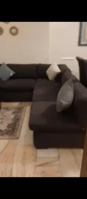 a black couch with pillows in a living room at عمان شارع مكه in Amman