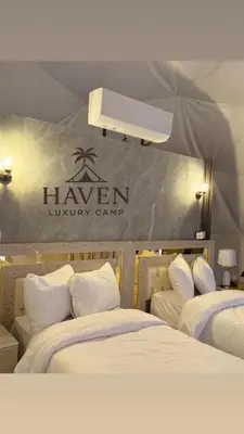 a sign that sayshaven luxury camp with two beds at Haven Luxury Camp in Aqaba