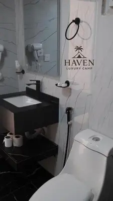 a bathroom with a white toilet and a sink at Haven Luxury Camp in Aqaba