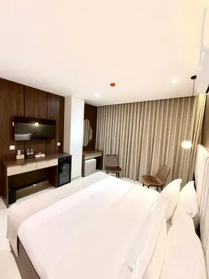 a bedroom with a large white bed and a desk at AL Hyatt Relax Hotel in Aqaba