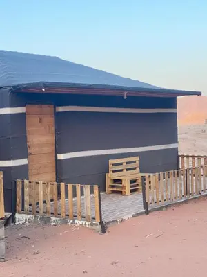 a blue building with a wooden porch and a bench at Kingdom of the Stars, Wadi Rum in Aqaba