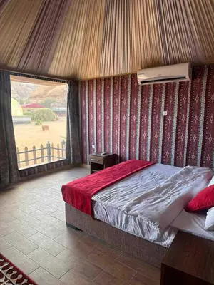 a bedroom with a bed and a view of a field at Wadi Rum cloud in Ma‘ān