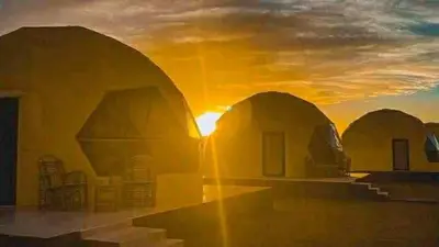 a group of domes with the sunset in the background at Wadi Rum cloud in Ma‘ān