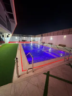 a large swimming pool at night with blue lights at Alma chalets in Aş Şarīḩ
