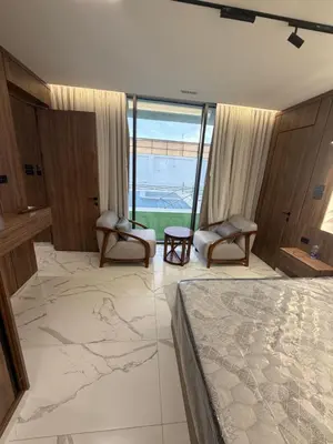 a bedroom with a bed and two chairs and a window at Alma chalets in Aş Şarīḩ