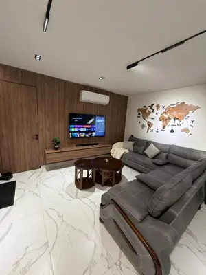 a living room with a couch and a tv at Alma chalets in Aş Şarīḩ