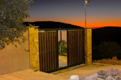 a building with a gate with the sunset in the background at Sultan Chalet Ajloun شاليه السلطان in Ajloun