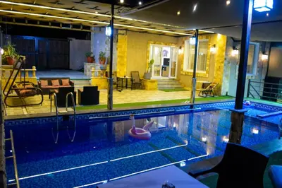 a large swimming pool in a building with a house at Sultan Chalet Ajloun شاليه السلطان in Ajloun