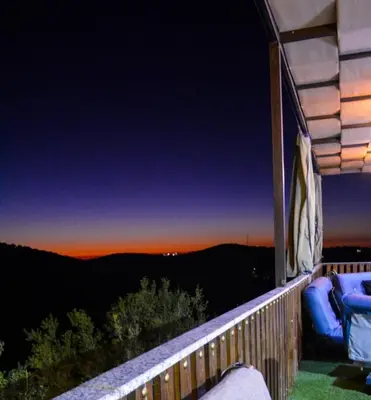 a balcony with a view of the mountains at night at Sultan Chalet Ajloun شاليه السلطان in Ajloun