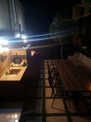 a patio with a table and chairs at night at Sultan Chalet Ajloun شاليه السلطان in Ajloun