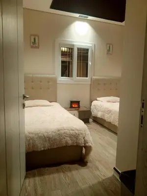 a bedroom with two beds and a fire in a room at Sultan Chalet Ajloun شاليه السلطان in Ajloun