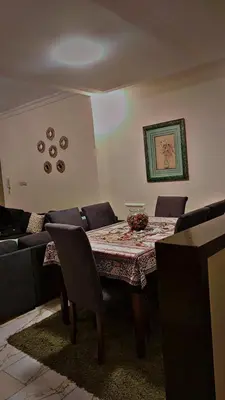a dining room with a table and a couch at شقه مفروشه للإيجار مكونه من 4 غرف في عمان in Amman
