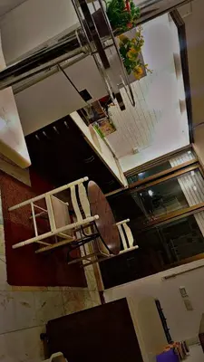 a staircase in a room with a table and chairs at شقه مفروشه للإيجار مكونه من 4 غرف في عمان in Amman