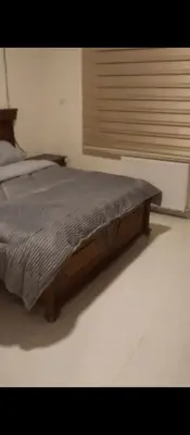 a bed with a wooden frame in a bedroom at شقه مفروشه بالكامل في عمان شارع مكه ضاحيه الأمير راشد in Amman