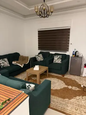 a living room with two green couches and a table at RoofTOP SPORTCITY in Amman
