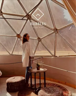 a woman is standing inside of a yurt at BUBBLES LUXURY CAMp in Wadi Rum