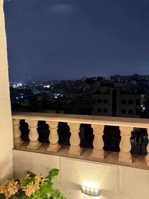 a view of a city at night from a balcony at Rooftop sport city in Amman