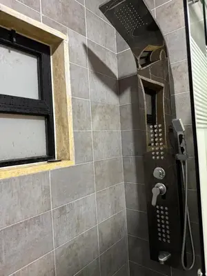 a shower in a bathroom with a window at Rooftop sport city in Amman
