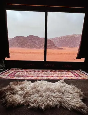 a furry rug on the floor in front of a window at Wadi Rum Bedoun in Wadi Rum