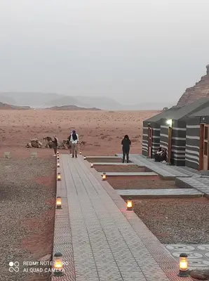 two people walking down a path in the desert at Oasis of Civilizations Camp in Wadi Rum