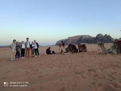 a group of people standing in the desert at Oasis of Wonders Camp in Wadi Rum