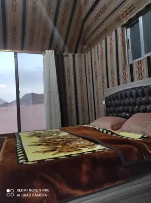 a bedroom with a bed with a view of the desert at Oasis of Wonders Camp in Wadi Rum