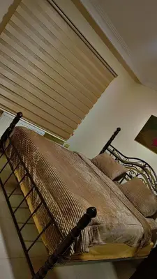a bed in a bedroom with a window with a blind at ضاحيه الأمير راشد in Amman