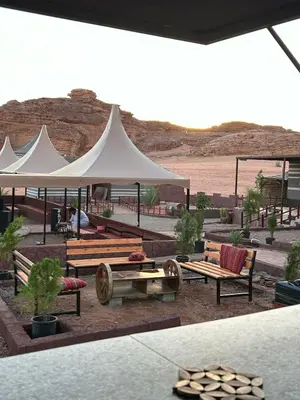 a picnic area with benches and a white tent at Rotana camp in Disah