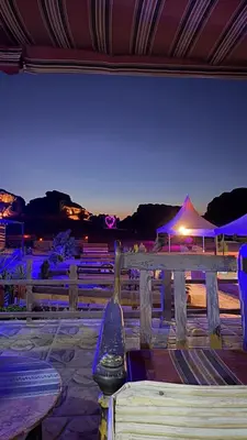 a bench with a view of a beach at night at Rotana camp in Disah