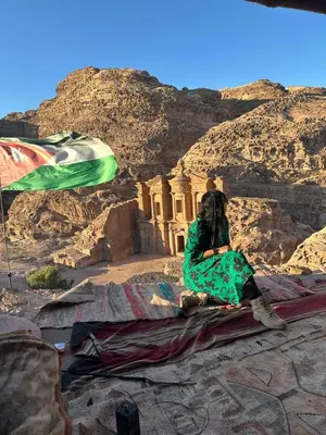 a woman sitting on top of a rock mountain at Nadina Bedouin home in Petra