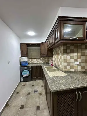 a kitchen with wooden cabinets and a counter top at Amman Jordan جبل عمان الدوار الاول in Ash Shumaysānī
