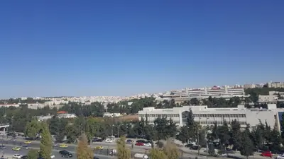 a view of a city with a parking lot and buildings at Al Khaleej Hotel Apartments in Amman