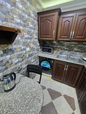 a small kitchen with a table and a stove at Cozy Studio 2 Central Amman, Near Rainbow Street in Amman