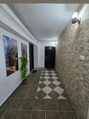 a hallway with a tile floor and a brick wall at Cozy Studio 2 Central Amman, Near Rainbow Street in Amman