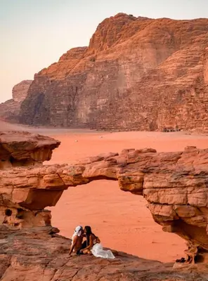 a dog sitting on a rock in the desert at Magic rum luxury camp in Wadi Rum